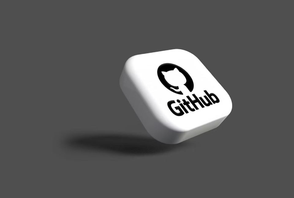 GitHub logo and lettering on a rounded, white 3D cube against a grey background.
